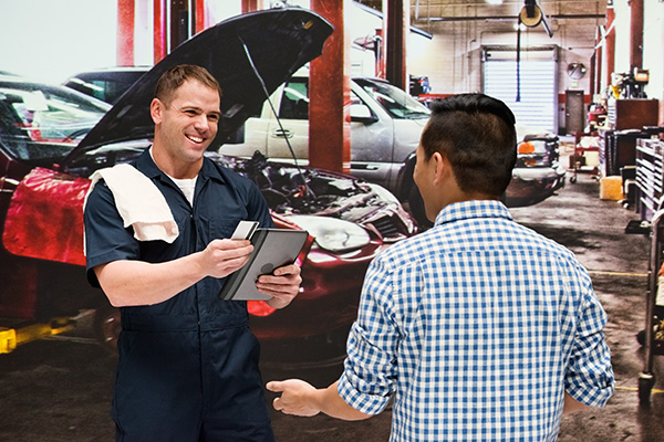 Mechanic discussion with client in auto repair shop